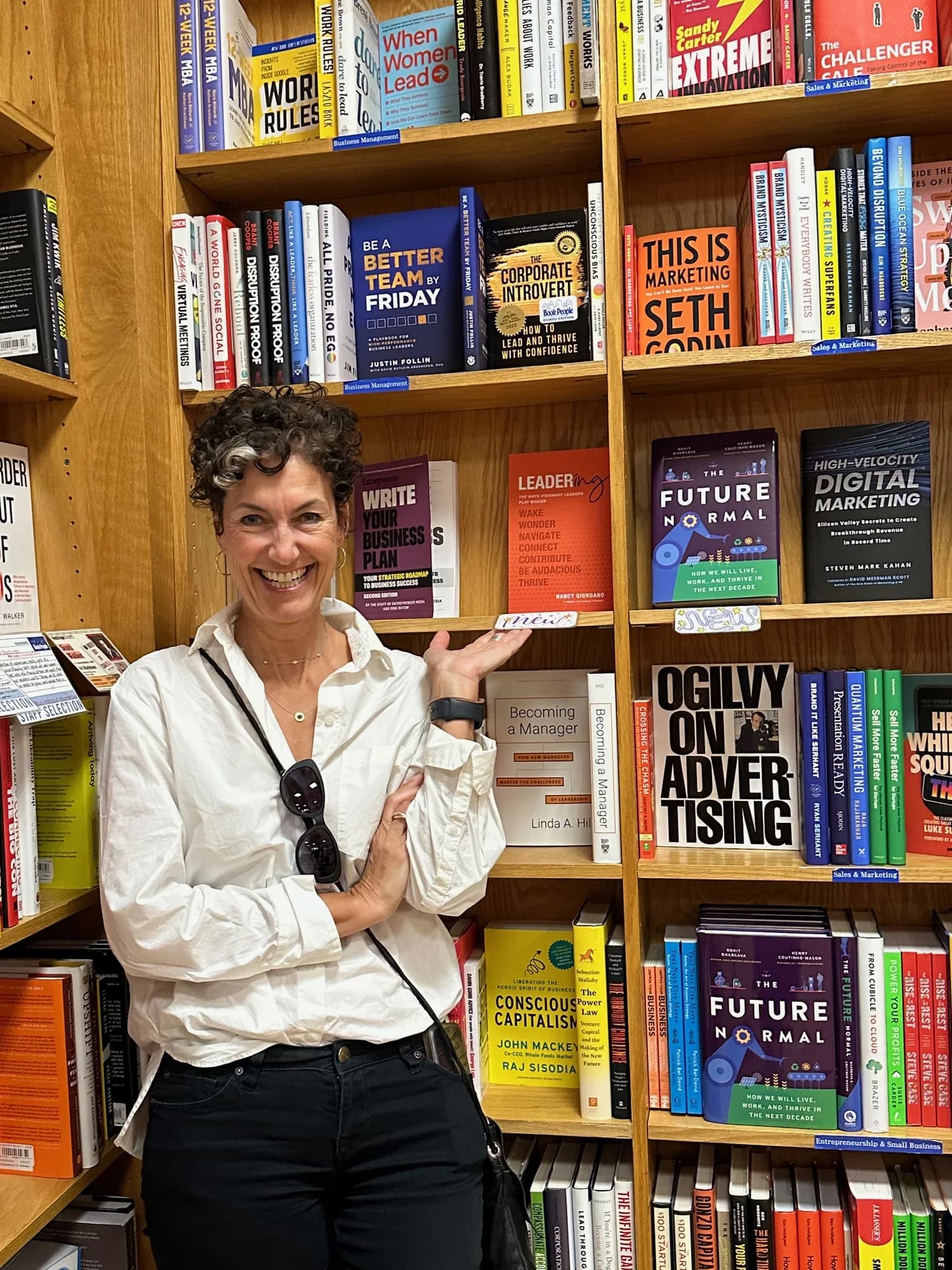 Nancy Giordano pointing at Leadering on a bookshop shelf